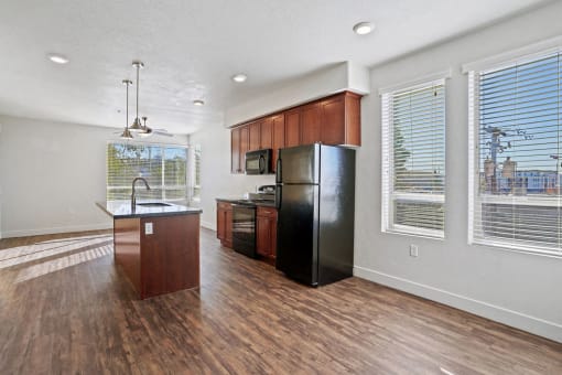 an empty kitchen with a refrigerator and a sink