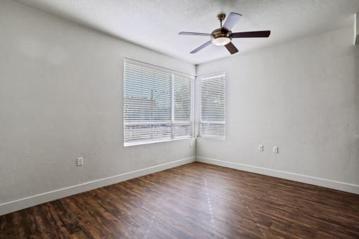 an empty room with a ceiling fan and a window