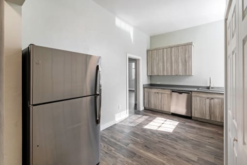 a kitchen with stainless steel appliances and wood flooring in a new home