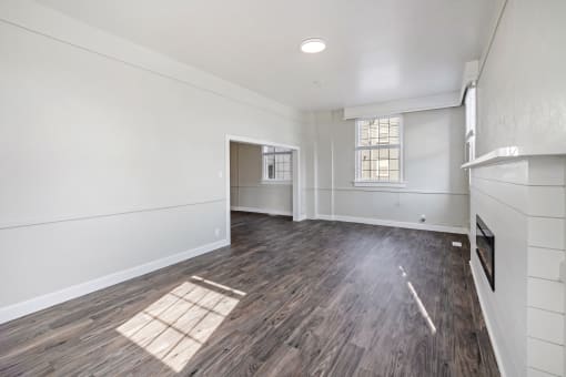 an empty living room with a fireplace and white walls