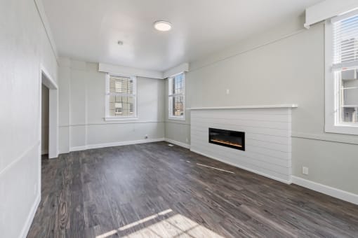 an empty living room with a fireplace and white walls