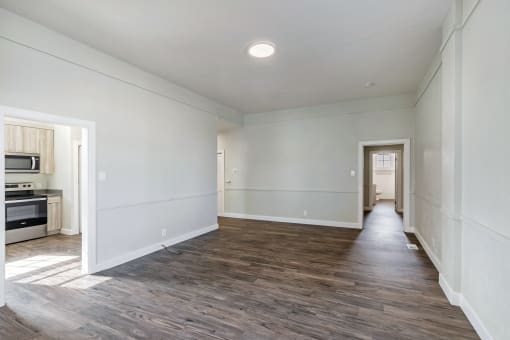 an empty living room with white walls and wood flooring