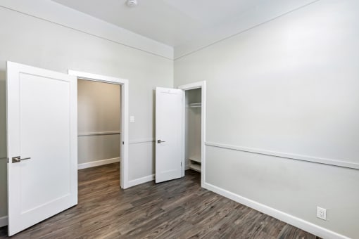 an empty room with white walls and a door to a closet