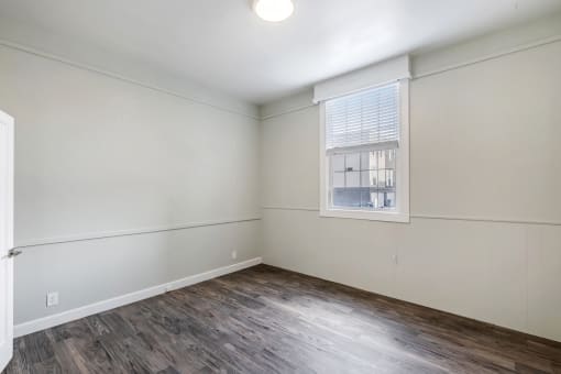an empty room with white walls and a window