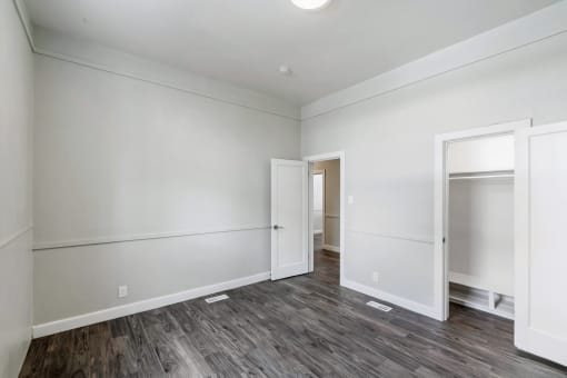 an empty living room with white walls and wood flooring