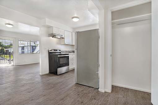 A kitchen with a stove top oven and a refrigerator.