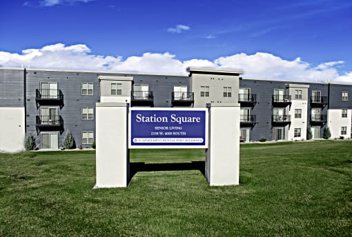 a sign that says station square in front of an apartment building