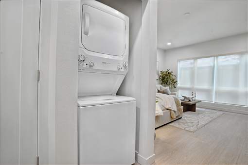 A white dryer is sitting in a room with a window.