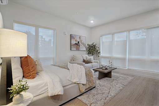 A well-lit bedroom with a large bed and a coffee table.