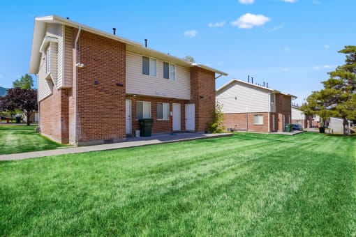 a large lawn in front of a brick house
