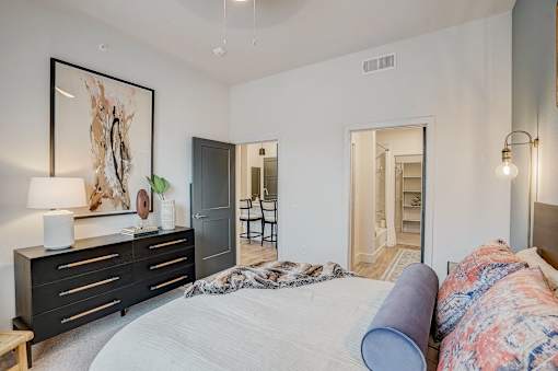 Spacious bedroom with walk-in closet and ensuite bathroom at The Mill Old Town Apartments, Lewisville, TX 75057