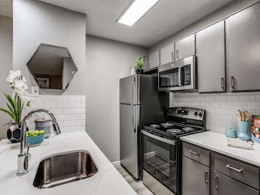Modern kitchen with stainless steel appliances at The Melville Apartments