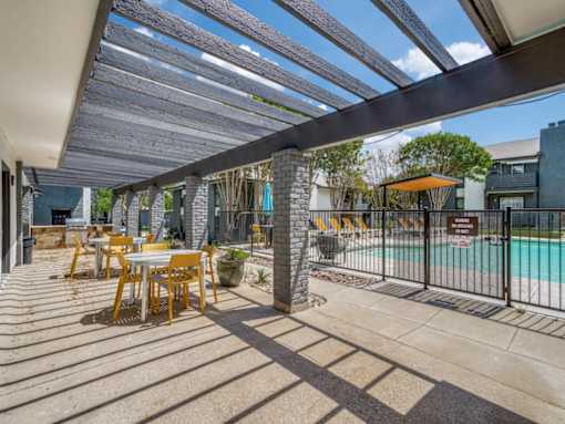 Outdoor covered seating and grilling area at The Melville Apartments