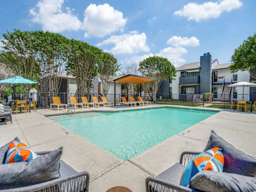 Resort-style swimming pool with lounge seating at The Melville Apartments