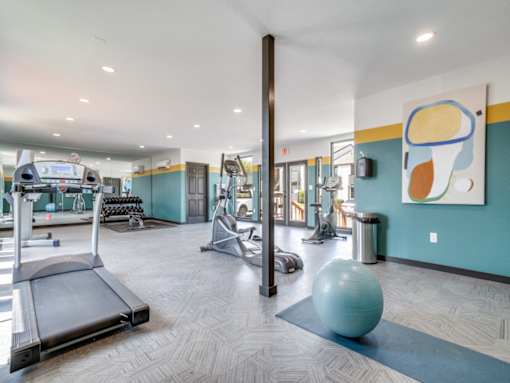 Modern fitness center with cardio and strength equipment at The Melville Apartment