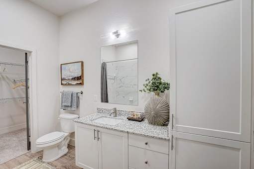 Modern bathroom with granite vanity and mirror at The Mill Old Town Apartments, Lewisville, 75057