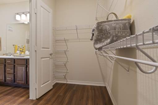 Walk-in closet with hanging space at Auberge of Tyler apartments in Tyler TX.