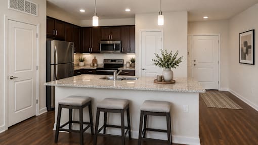 Spacious kitchen with a center island, bar seating, and stainless steel appliances at Auberge of Tyler.