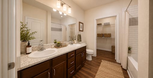 Modern bathroom with a spacious vanity, large mirror, and updated fixtures in a two-bedroom apartment at Auberge of Tyler.