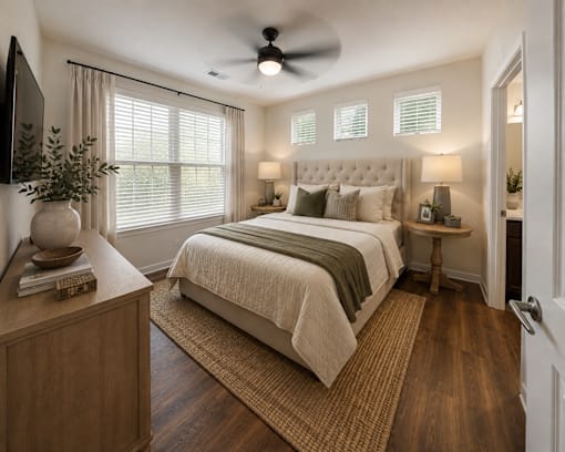 Primary bedroom with large windows, ceiling fan, and modern finishes in a two-bedroom apartment at Auberge of Tyler.