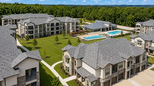 Aerial view of the apartment buildings, green spaces, and covered parking at Auberge of Tyler.