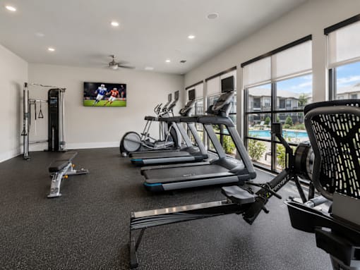 Modern fitness center with cardio equipment, strength machines, and free weights at Auberge of Tyler.