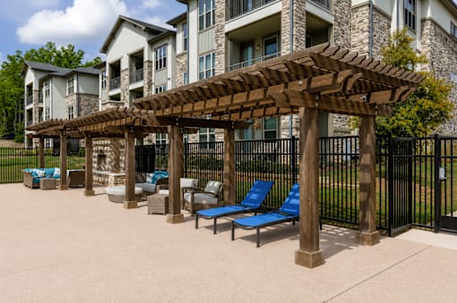Shaded poolside pergola with lounge seating beside the swimming pool at Auberge of Tyler.