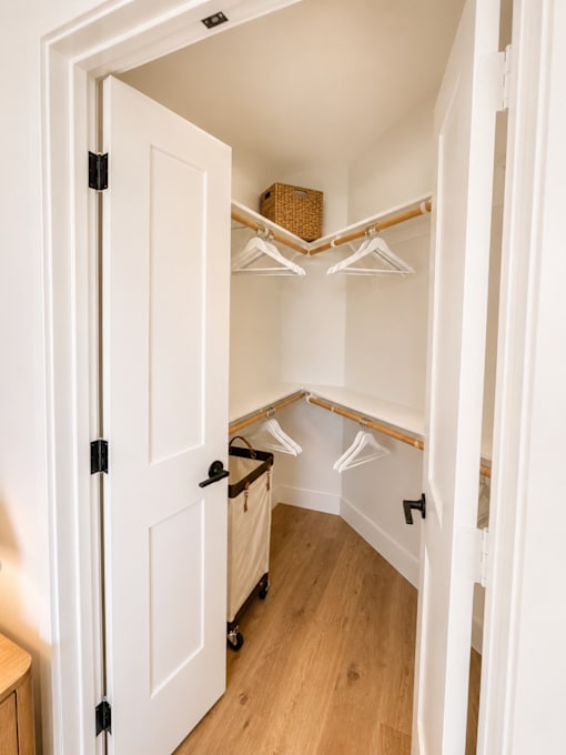 Spacious walk-in closet with built-in shelving and hanging space.