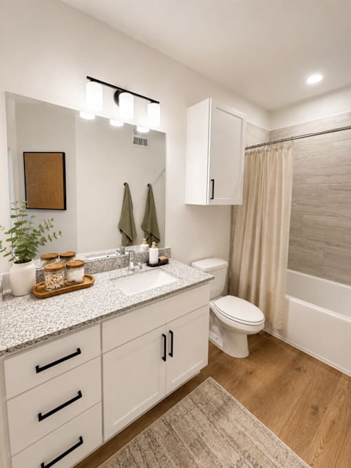 Stylish bathroom with granite countertop, contemporary fixtures and storage.
