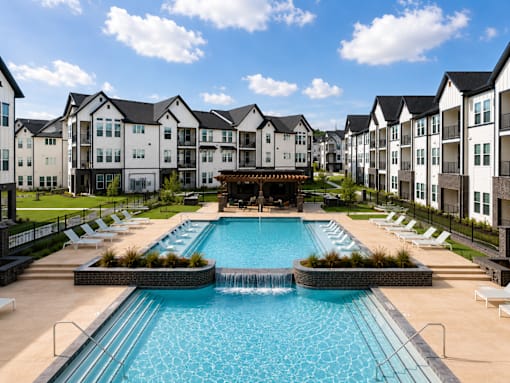 Resort swimming pool with tanning ledges at The Bluewood apartments