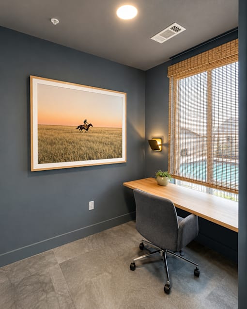 Zoom room with a desk, chair, and a framed picture of a horse on the wall.