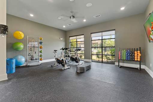 A spacious gym with a variety of exercise equipment and fitness balls.