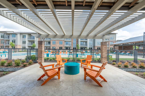 a patio with a table and chairs and a pool in the background at One Preston Station, Texas