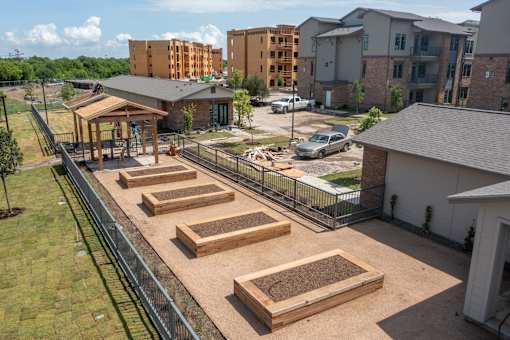Community garden with raised planting beds at One Preston Station Apartments in Celina, Texas.