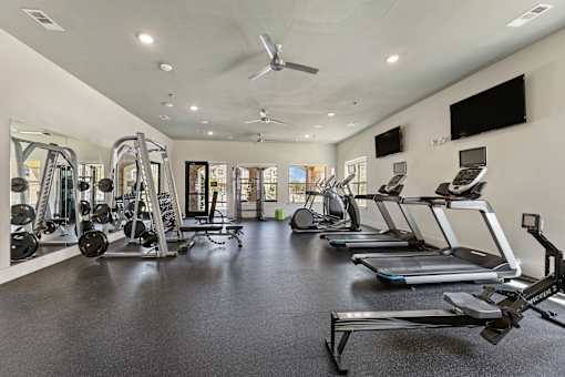 Fitness center with treadmills and ellipticals at Auberge of Burleson apartments in Burleson TX.