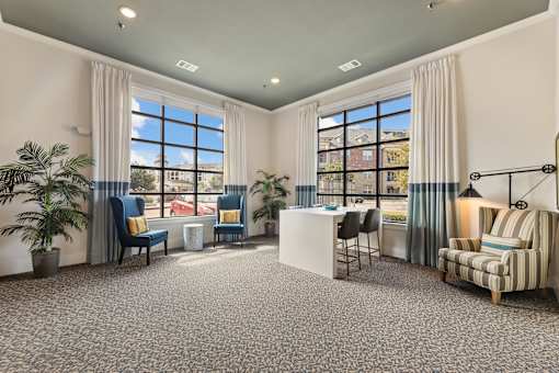 Clubhouse lounge and business center with large windows at Auberge of Burleson luxury apartments in Burleson TX.