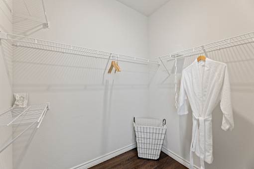 A white bathroom with a white robe hanging on the wall.