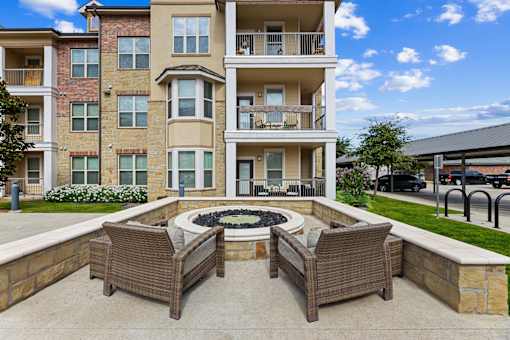 Clubhouse patio seating area and fire pit at Auberge of Burleson luxury apartments in Burleson TX.