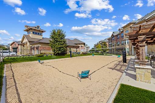 Sand Volleyball area with seating at Auberge of Burleson apartments in Burleson TX.