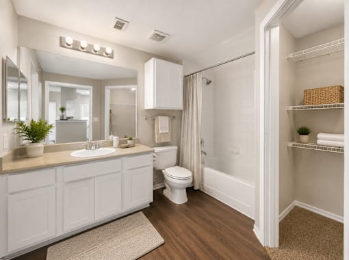A white bathroom with a toilet, sink, and shower.