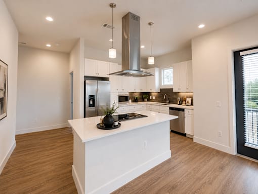 Open-concept kitchen with oversized island, quartz countertops, and modern cabinetry at The Mill Old Town Apartments.
