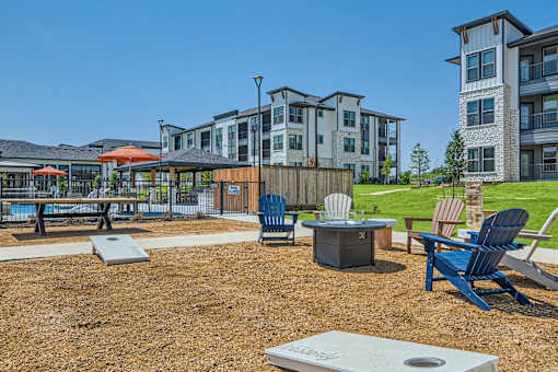Outdoor recreation area with fire pit and cornhole at The Westerly Apartments, Midlothian, TX 76065