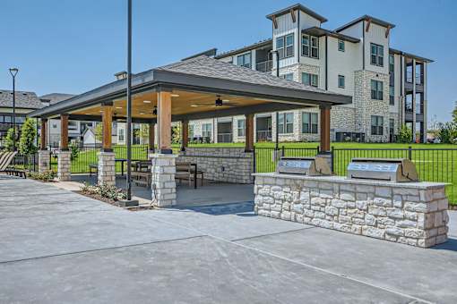 Covered outdoor pavilion with grills and seating at The Westerly Apartments, Texas