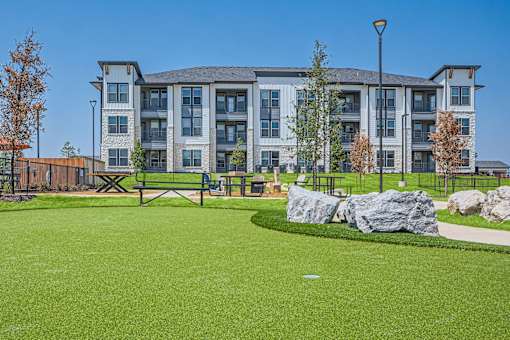 Outdoor amenity area with artificial turf and boulders at The Westerly Apartments, Midlothian, 76065