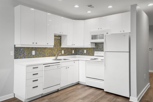 Kitchen with White Cabinets at Sleek Lofts