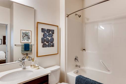 A bathroom with a white sink and a white bathtub.