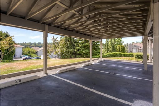 A parking lot with a roof and a number 26 painted on the ground.