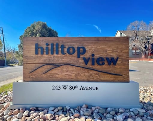 A wooden sign with the words "hilltop view" on it.