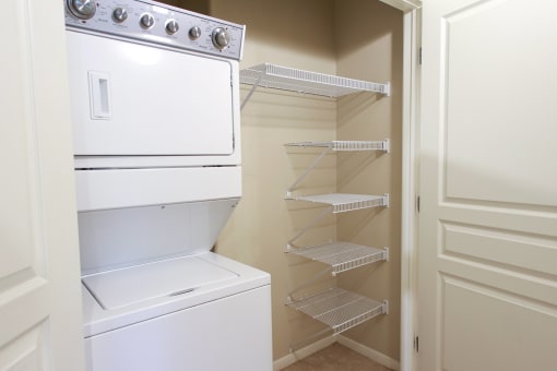 Apartments in North Las Vegas NV with In-Unit Washer and Dryer - Sonata - In Unit Laundry Closet With Stacked Washer And Dryer, Multiple Wire Shelving Racks, And Convenient Interior Storage Space