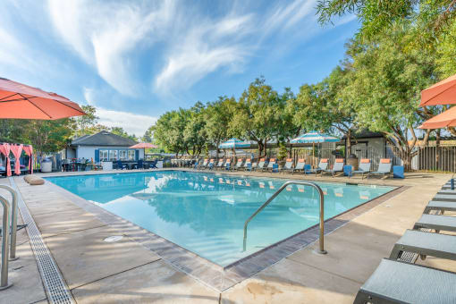 Our resort style swimming pool is filled with lounge chairs and umbrellas